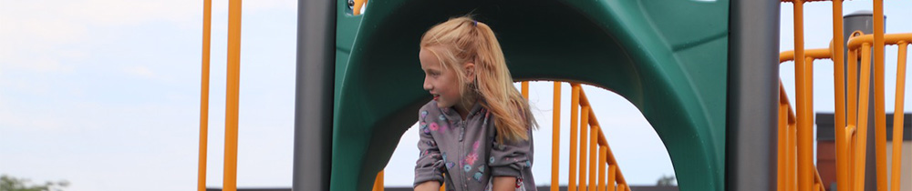 Girl climbing on playground equipment.