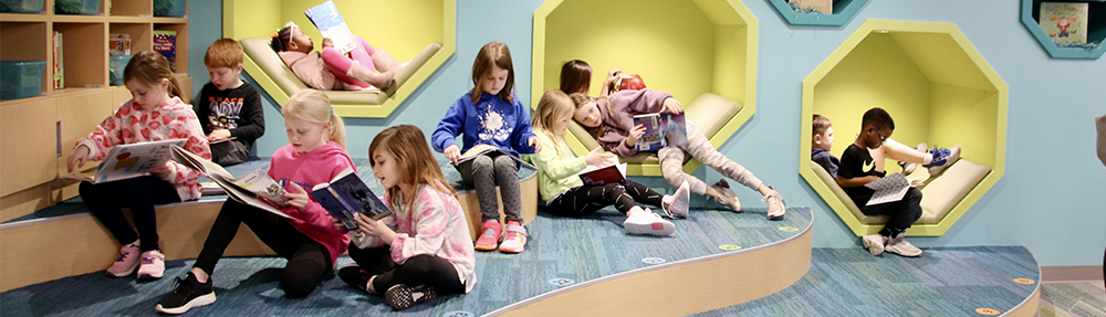 Kids sitting and laying around reading.