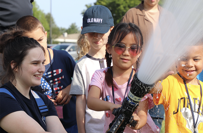 Kids playing with a fire hose.