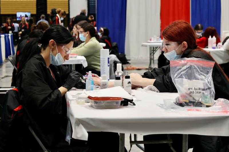 One teen girl doing another teen girl's nails.