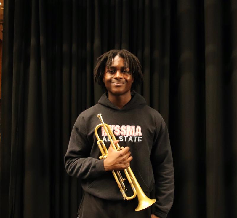 Teen holding a trumpet and wearing shirt that says 'NYSSMA All State'