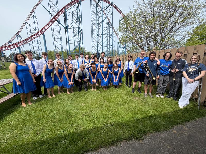 Large group of teens dressed and bright costumes plus teachers.