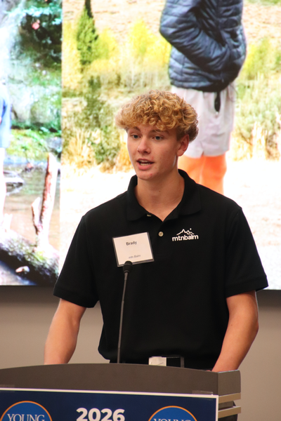 Teen standing at a podium talking. 