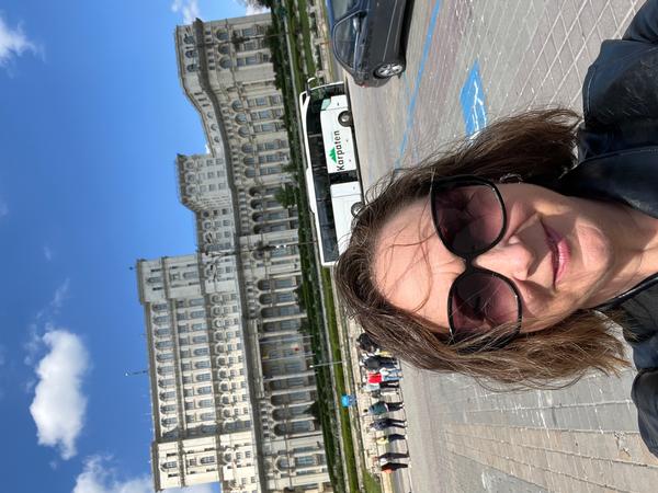 Woman in front of a massive ornate building.