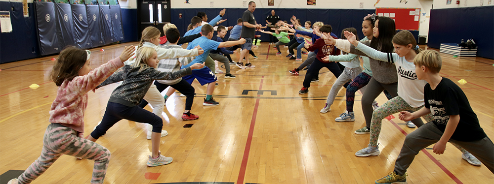 Students lined up doing a lunge.