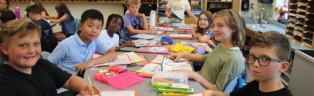 Fifth graders sitting at a long table.