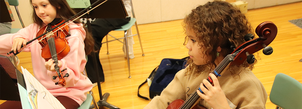 two girls playing string instruments.