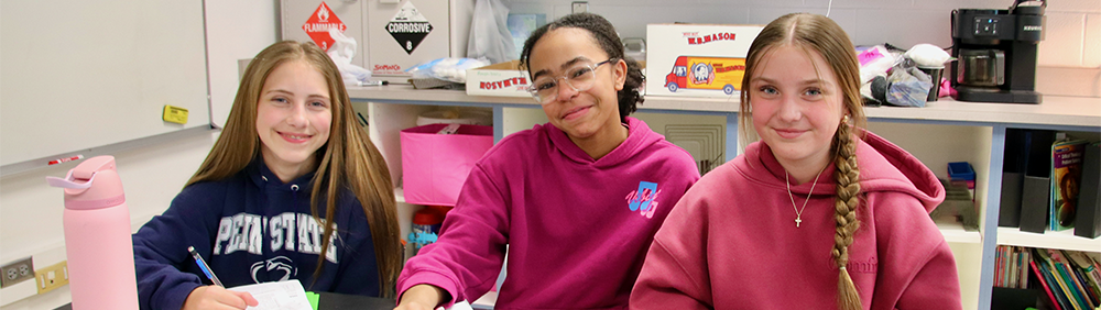 Three adolescent girls smiling at the camera