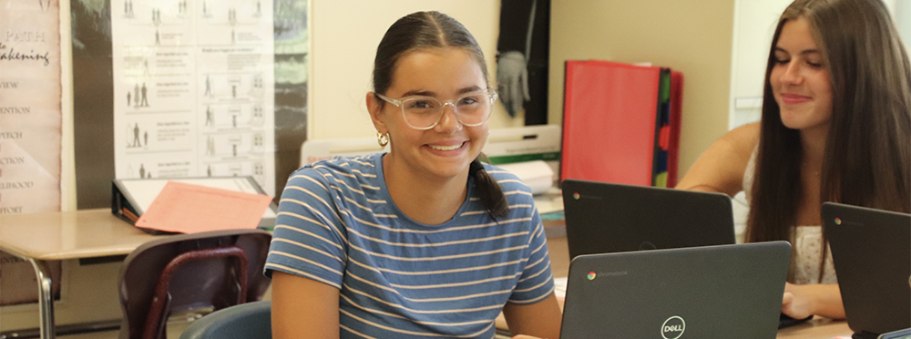 A teenage girl working at her laptop.