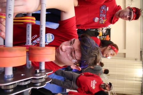 teen boy working on a robot.